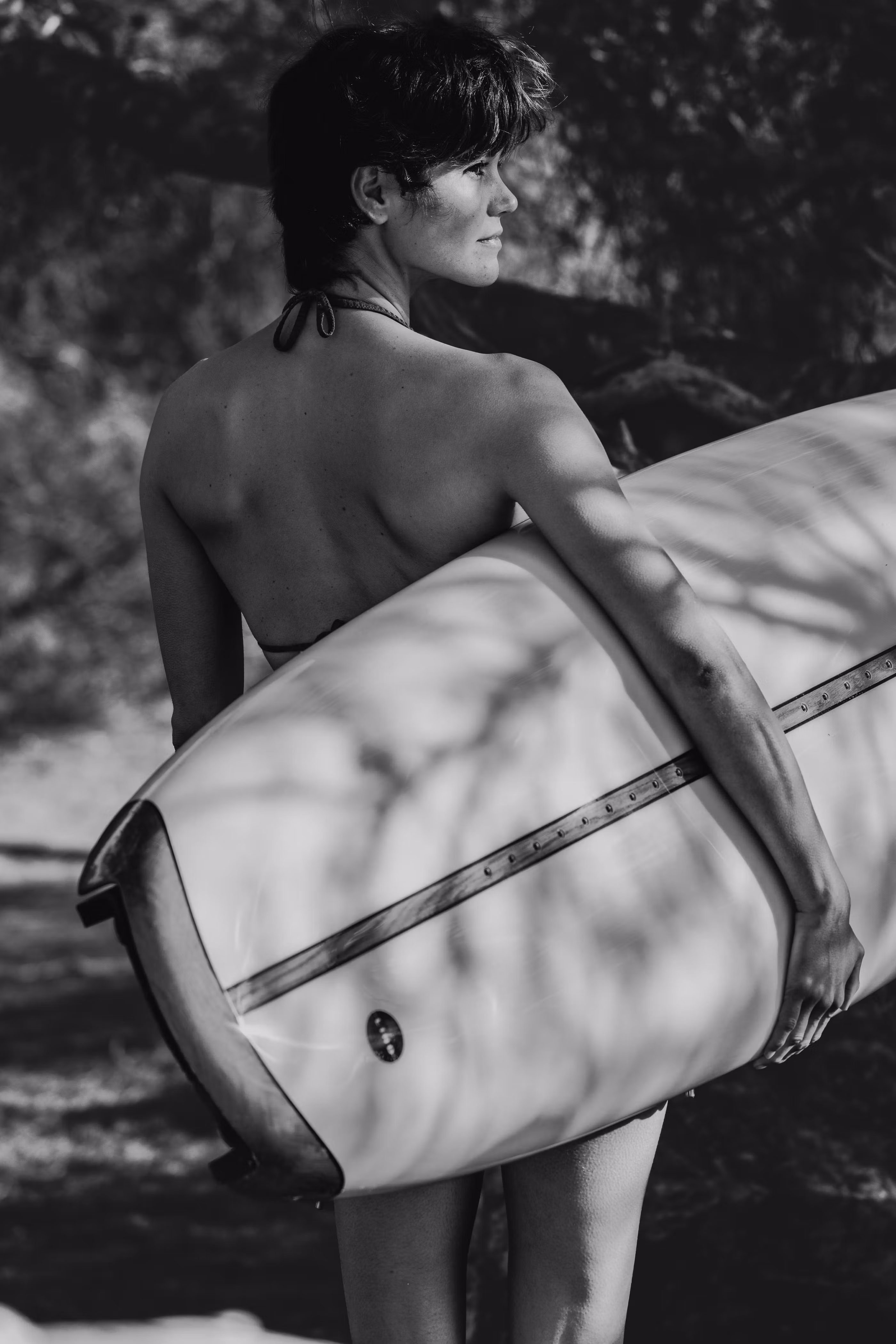 Surfer carrying a LIND electric surfboard under their arm