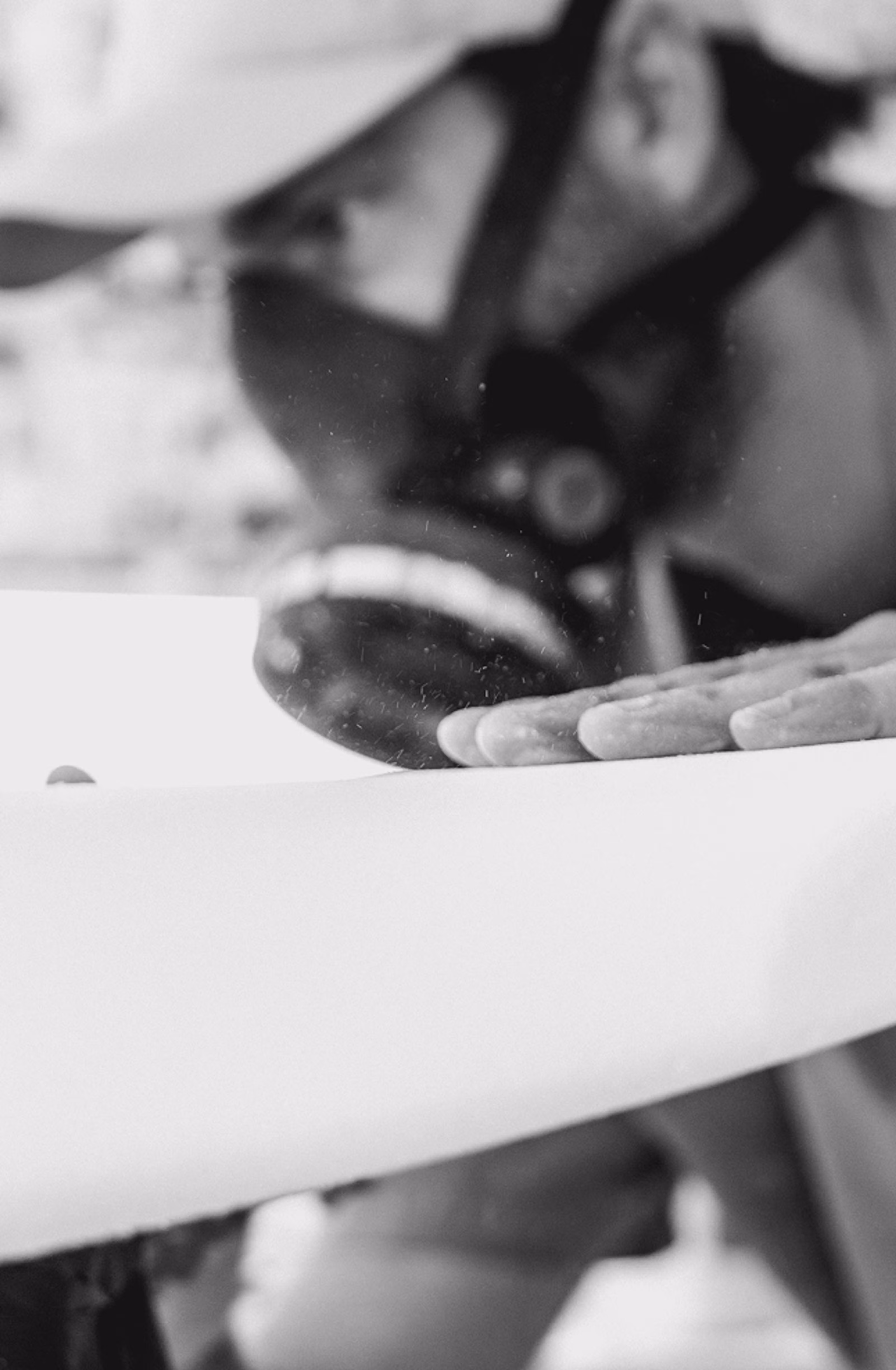 Shaper sanding the rail of a LIND electric surfboard during crafting